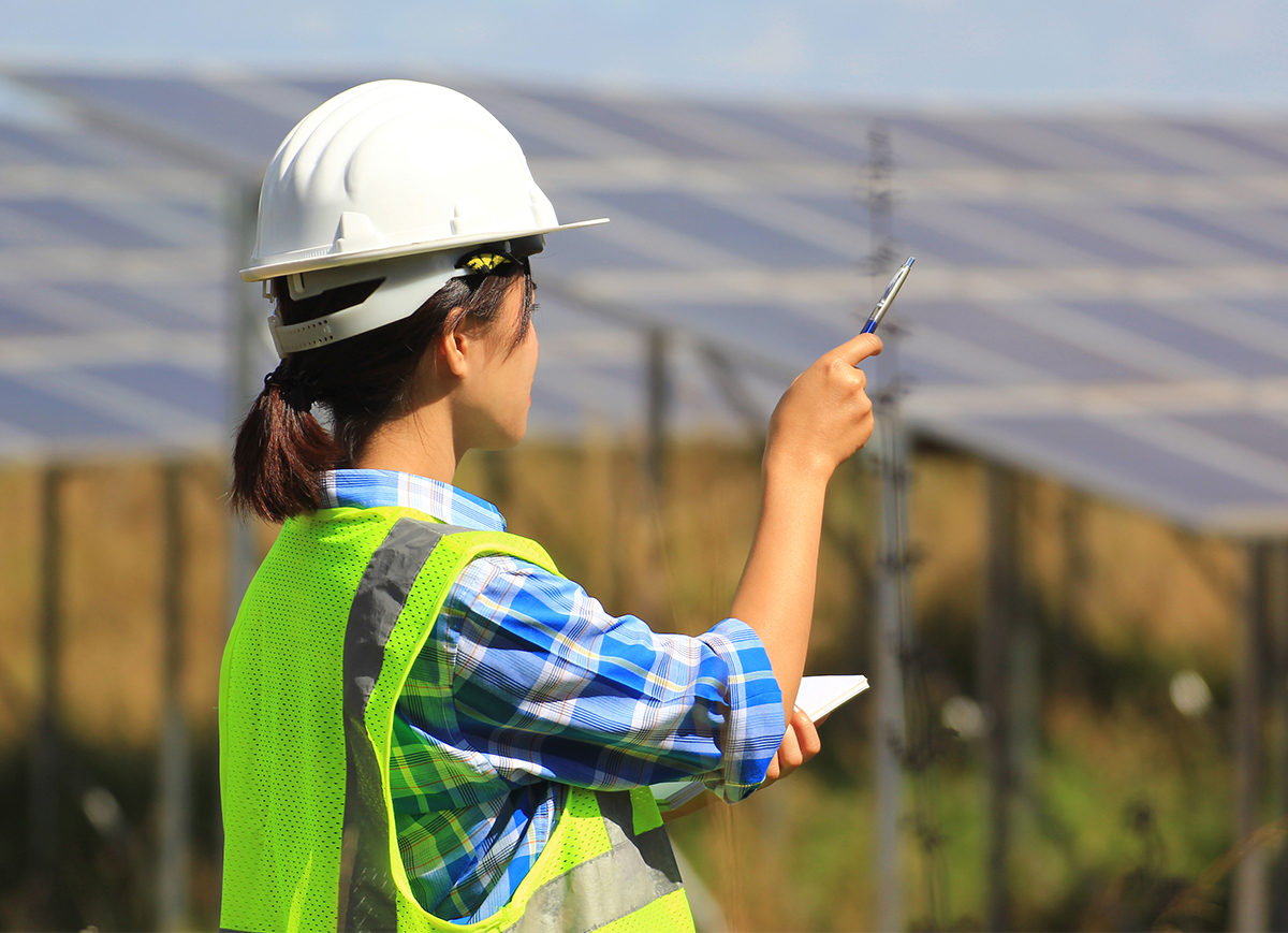 Female engineer in front of solar panels