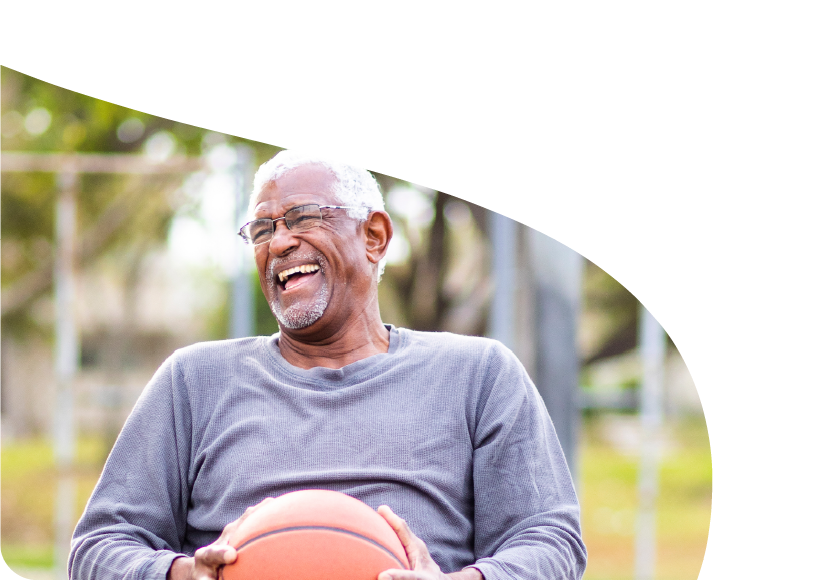 An older man playing basketball in a wheelchair. 