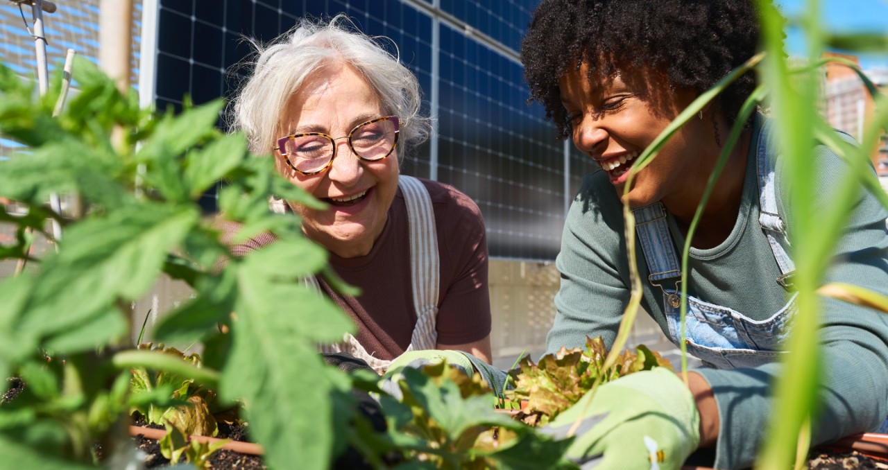 Two multigenerational women happily work together in a garden