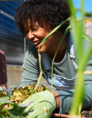 A woman happily works in a garden