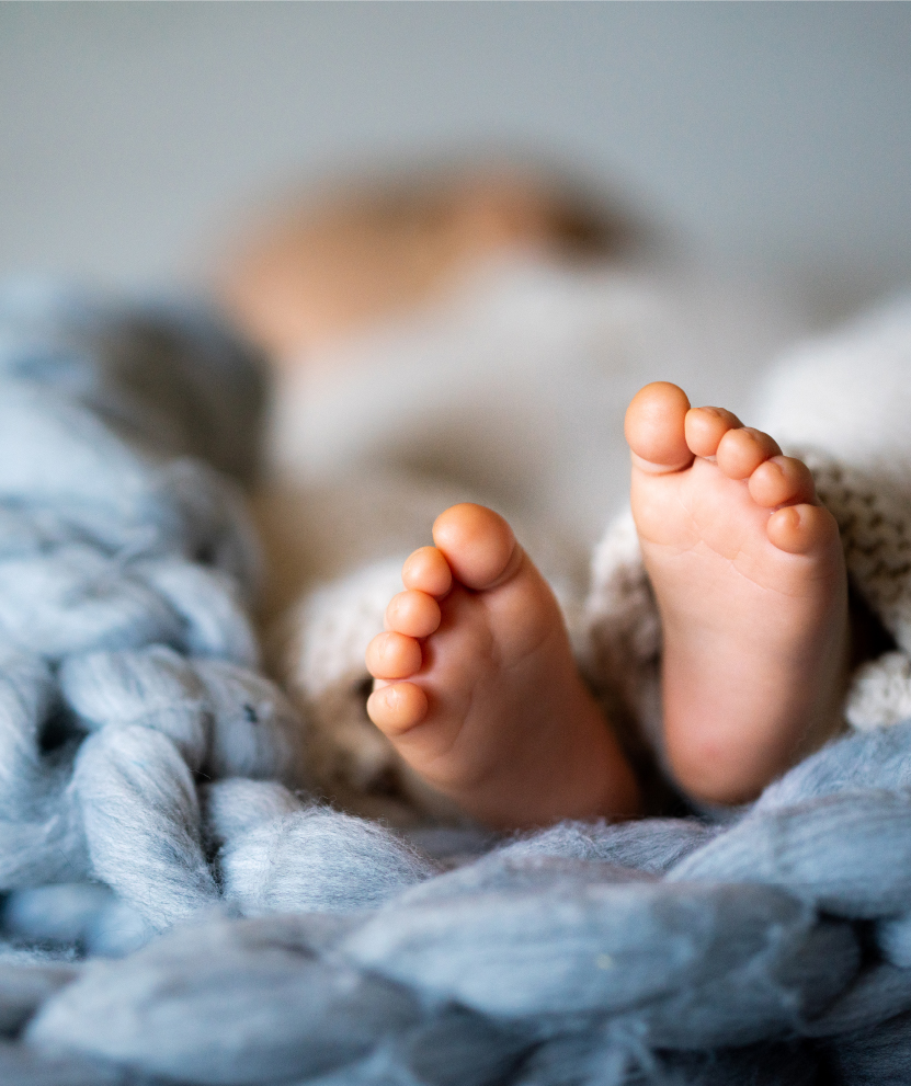 Newborn baby's feet wrapped in blue blanket