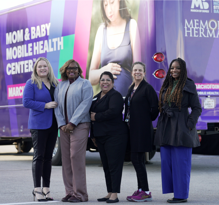 Group of women stand in front of Mom and Baby Mobile Health Center