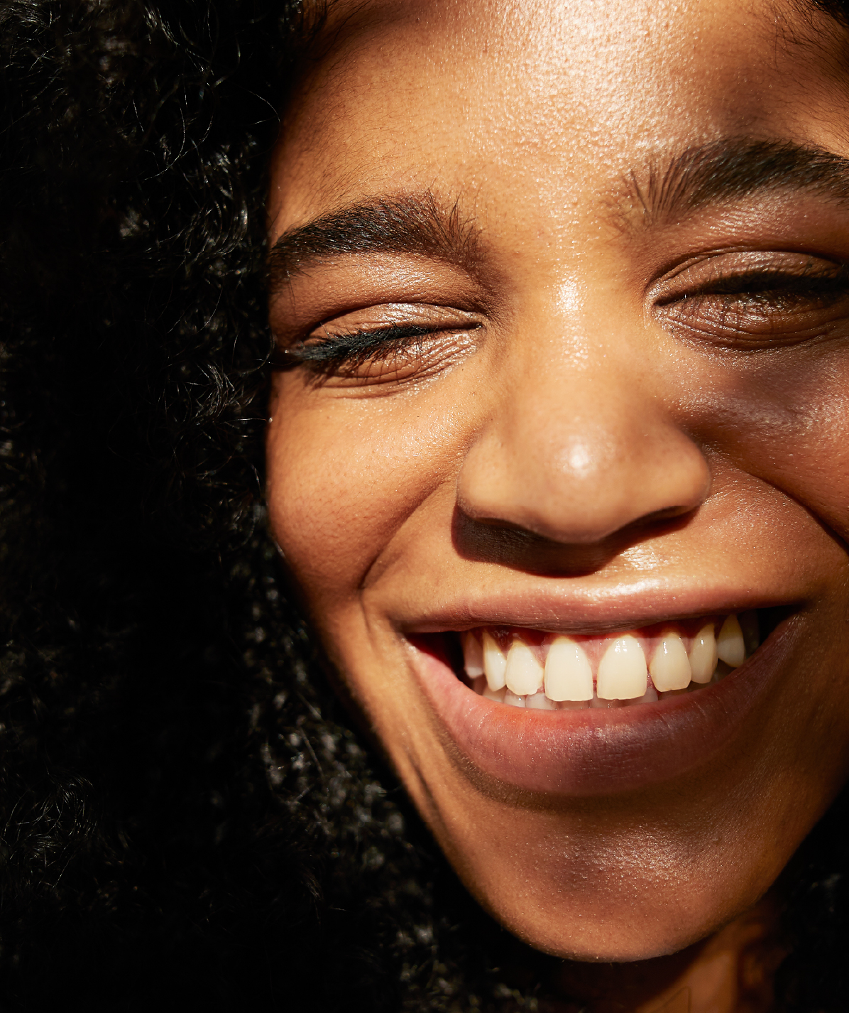 HCSC- An African American woman smiles and squints basked in light