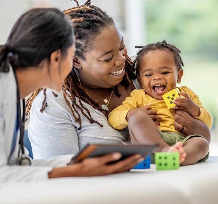 Smiling mom holds smiling baby during doctor visit