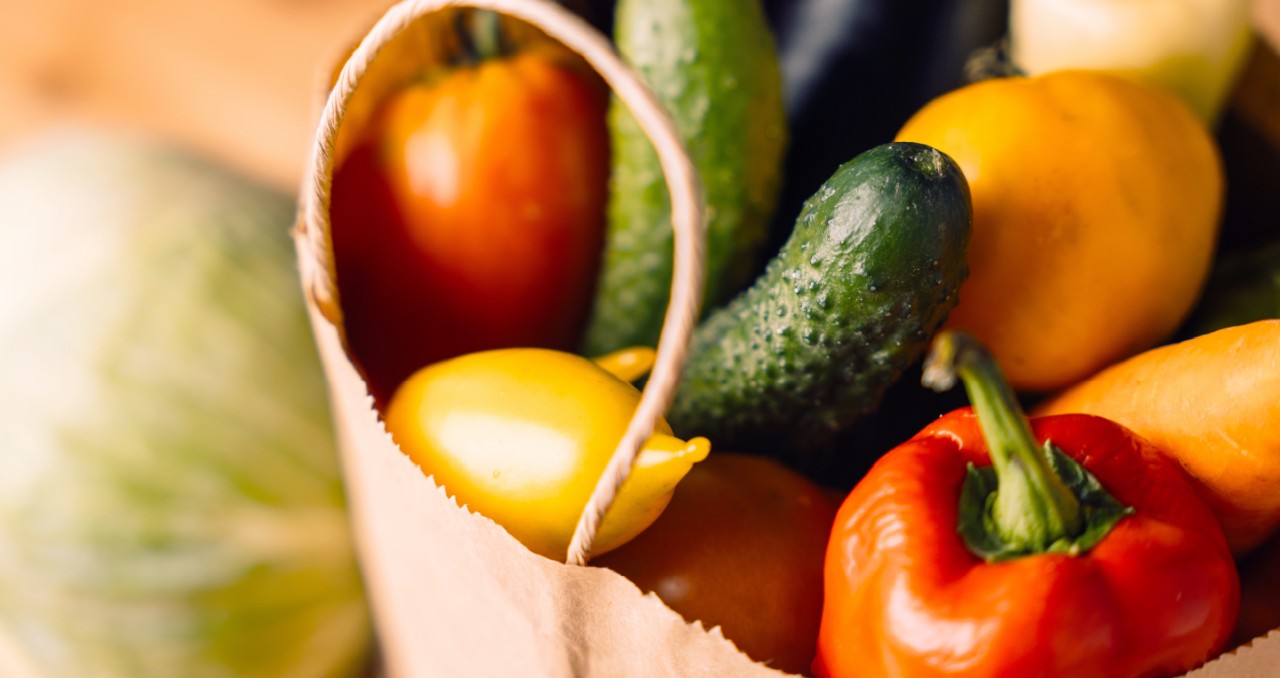 Paper bag full of bright vegetables