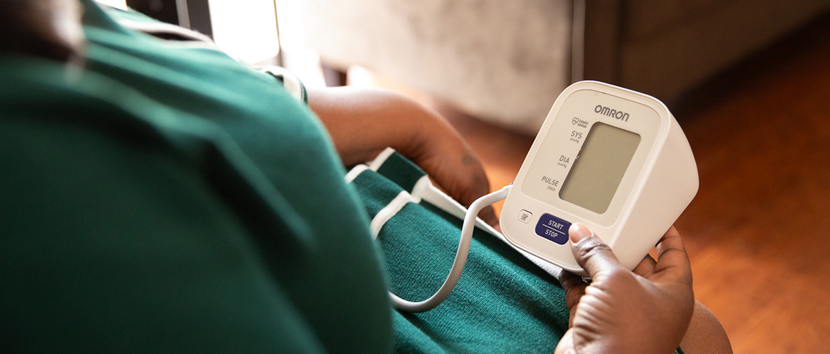 mom participating in InovCares program holds blood pressure monitor