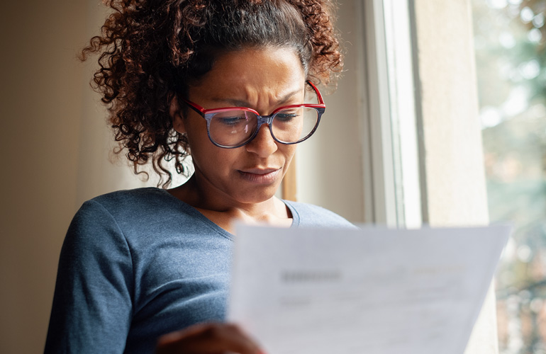 frustrated woman looks at medical bill