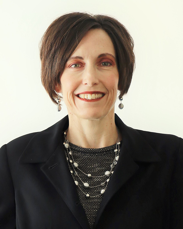 Woman in dark blazer smiles for a professional portrait