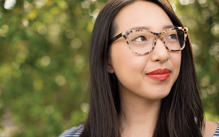 Woman wearing glasses gazes to her left